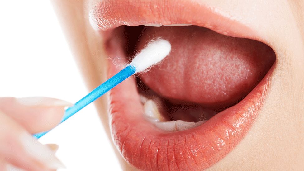 Woman taking swab from mouth