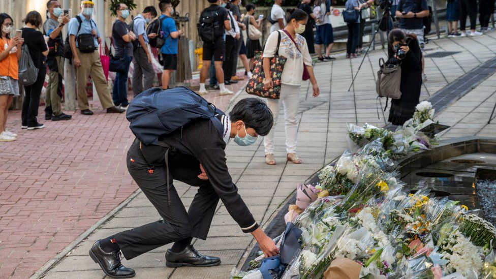 File photo of a mourner placing a flower bouquet outside the British Consulate General