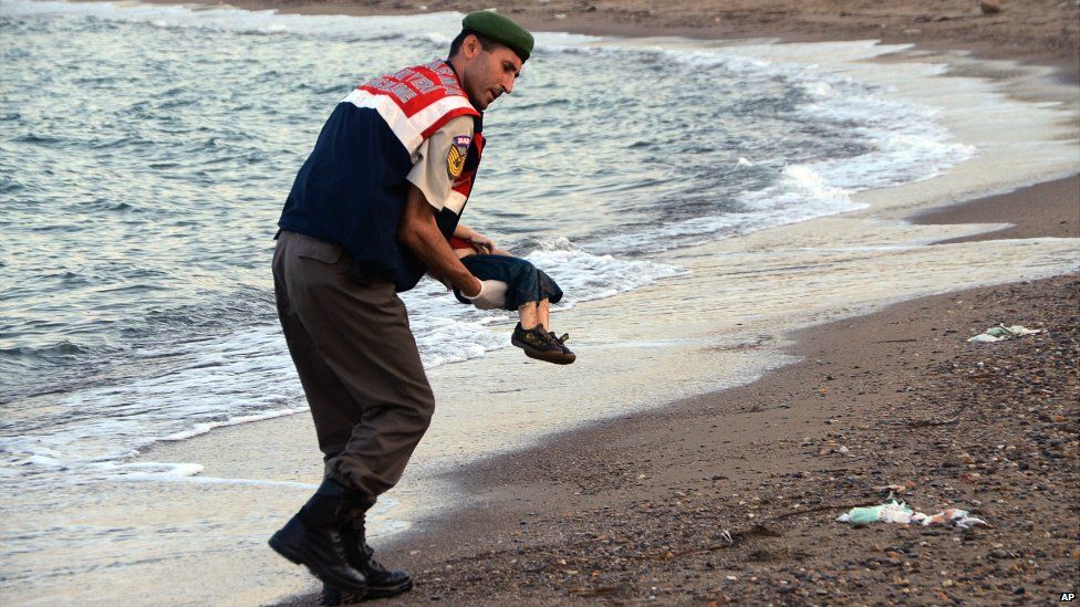 A paramilitary police officer carries the lifeless body of a migrant near the Turkish resort of Bodrum - 2 September 2015