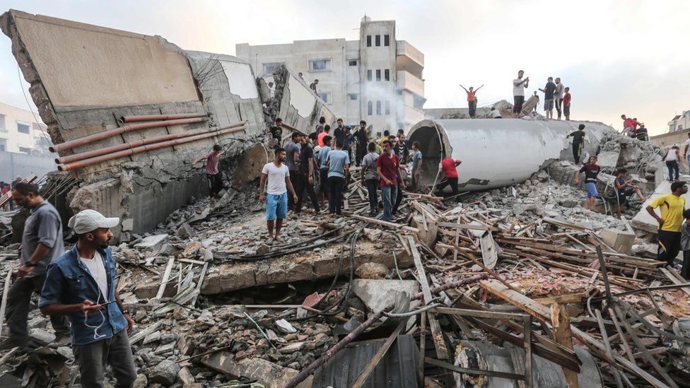 Palestinians search the remains of a cultural centre destroyed in an Israeli air strike on Gaza (9 August 2018)
