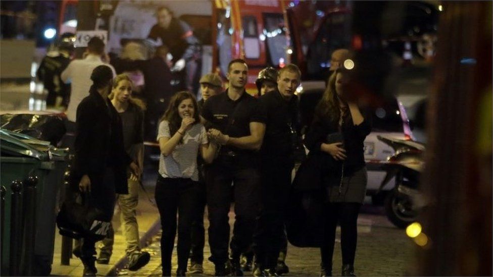 Rescuers evacuate people following an attack in the 10th arrondissement of the French capital Paris