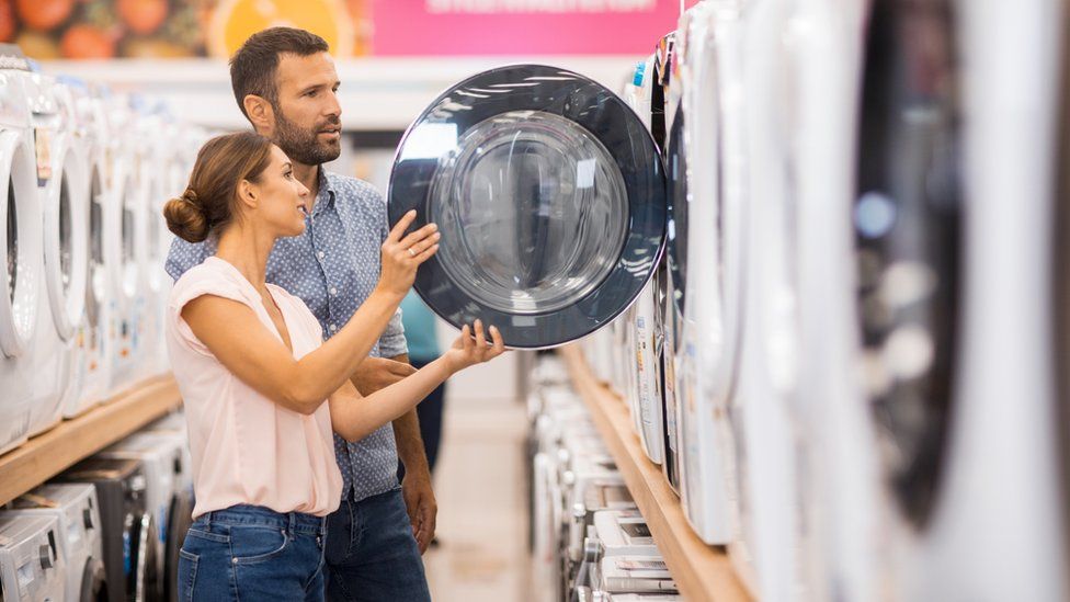 Couple looking at a washing machine in a shop