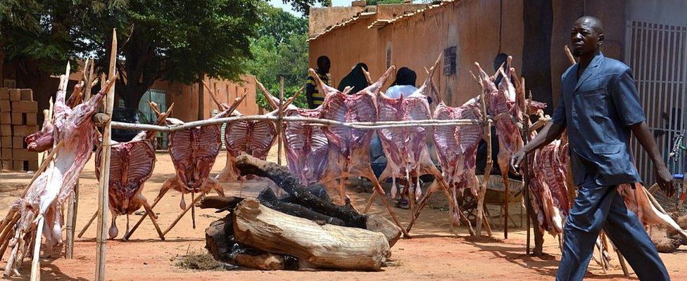 A man walks past sheep carcases staked around a log fire along a street in Niamey as Muslims celebrate Eid al-Adha on September 12, 2016. Muslims across the world celebrate the annual festival of Eid al-Adha, which marks the end of the Hajj pilgrimage to Mecca and commemorates prophet Abraham's readiness to sacrifice his son to show obedience to God.