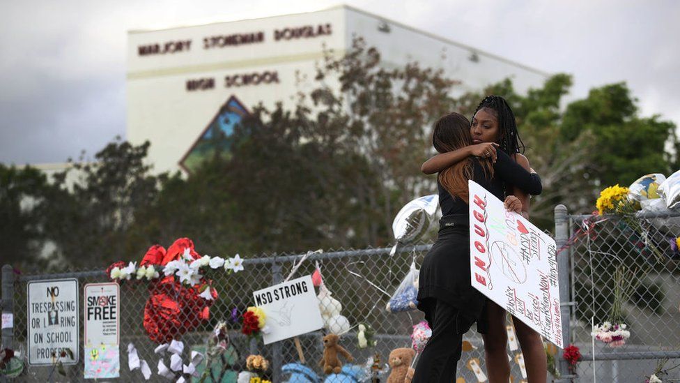 Tyra Heman (R) a senior at Marjory Stoneman Douglas High School, is hugged by Rachael Buto in front of the school