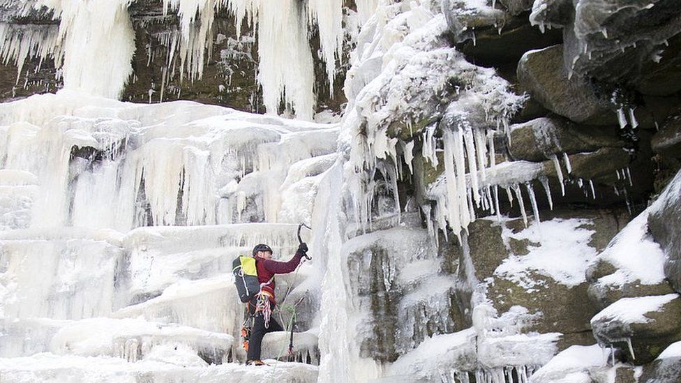 Climber on a frozen over Kinder Downfall