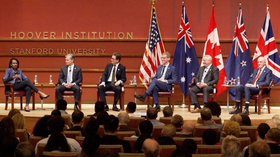 The heads of US, UK, Australian, Canadian and New Zealand security agencies sitting in a row at a public event.