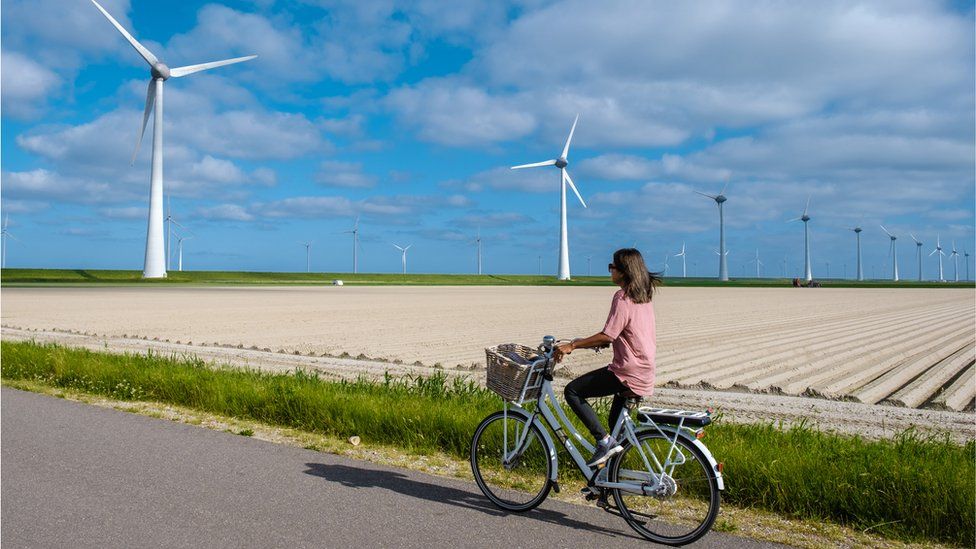 Велосипедист перед ветряными турбинами