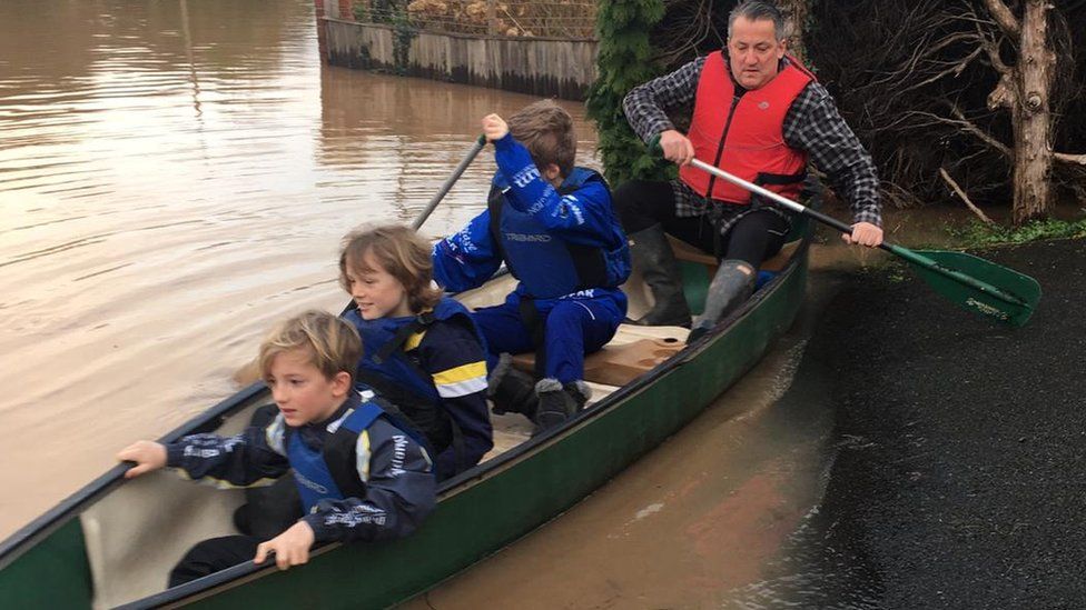 Alun Thomas with Ioan, Bowen and Harri sitting in a small boat