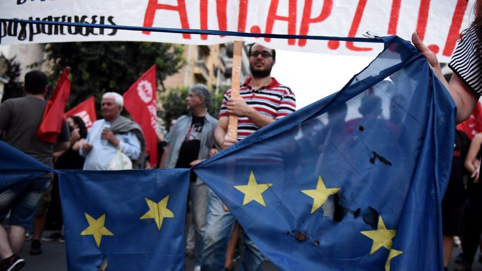 Demonstrators destroy a European flag during a rally by supporters of a "No" vote in Thessaloniki