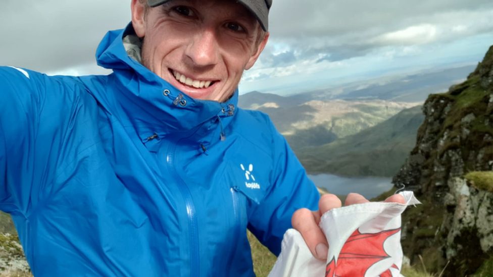Will Renwick flies the Welsh flag on the summit of Snowdon