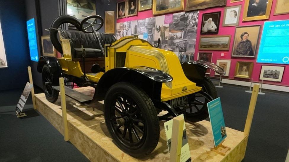 An old motor car on display at a museum