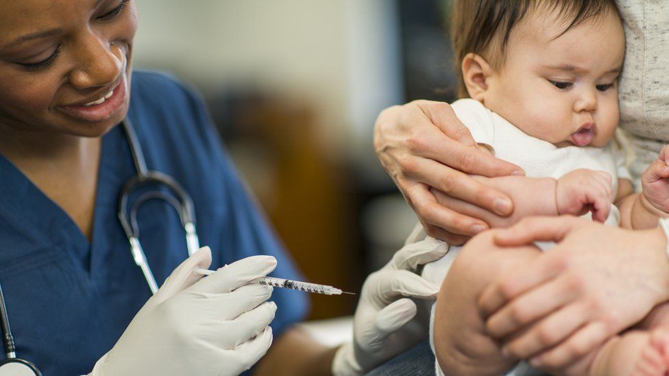 nurse giving an infant a vaccine