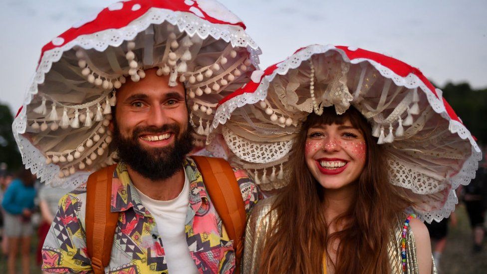 A couple in fancy dress pose for a photograph during day one of Glastonbury Festival