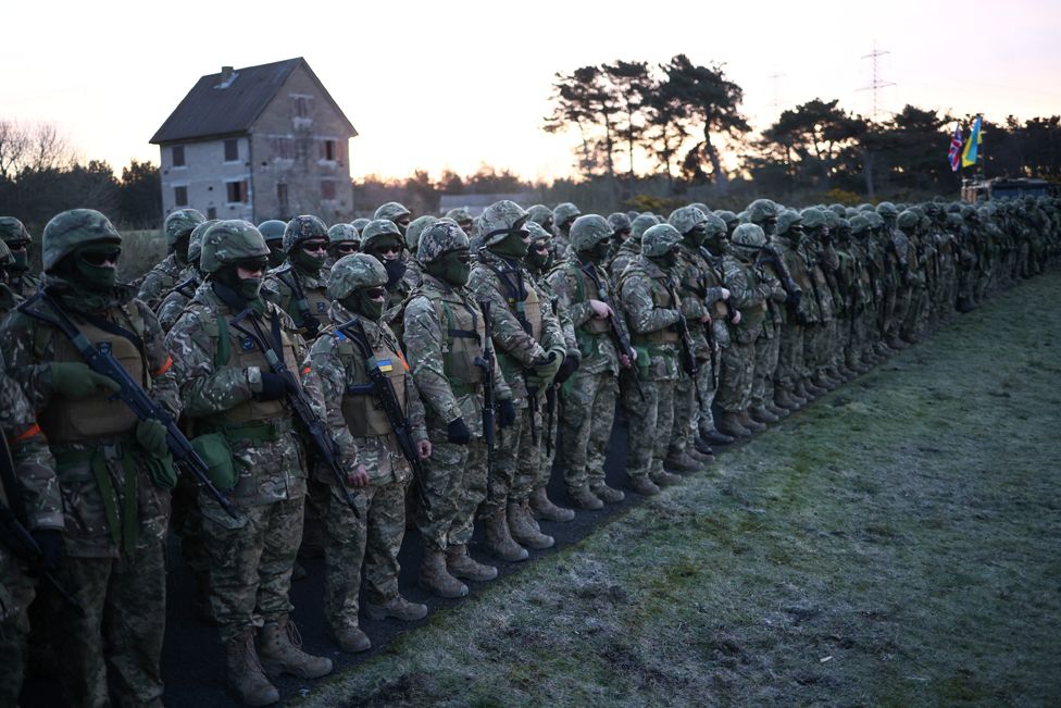 Ukrainische Militärrekruten stellen sich in einer Militärbasis im Südosten Großbritanniens auf, bevor sie an Gebeten, Segenssprüchen und einer Schweigeminute an der Seite britischer und kanadischer Truppen teilnehmen, um den ersten Jahrestag der russischen Invasion in der Ukraine zu begehen, 24. Februar 2023.