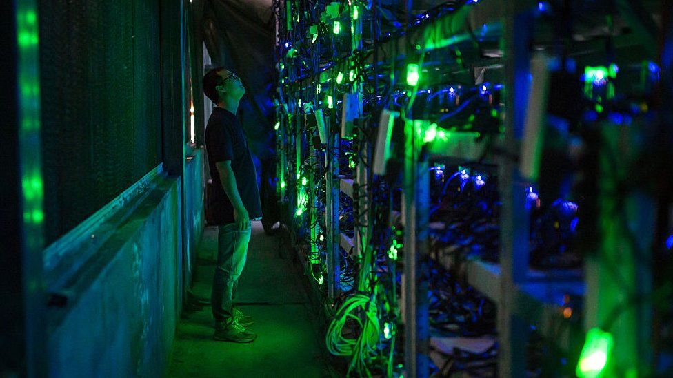 Man staring at CPUs in Chinese bitcoin mine.