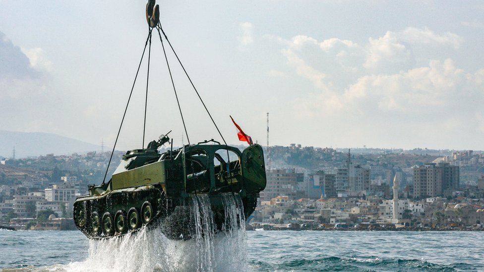 Environmental activists drop off old battle tanks provided by the Lebanese Armed Forces into the Mediterranean Sea