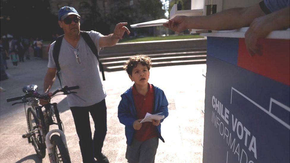 A citizen receives a copy of the proposed new Chilean constitution ahead of the upcoming December 17 constitutional referendum, outside the government pal