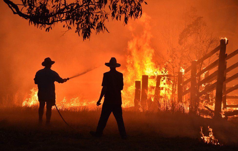 Residents, silhouetted against the flames, battle a bushfire in Australia.