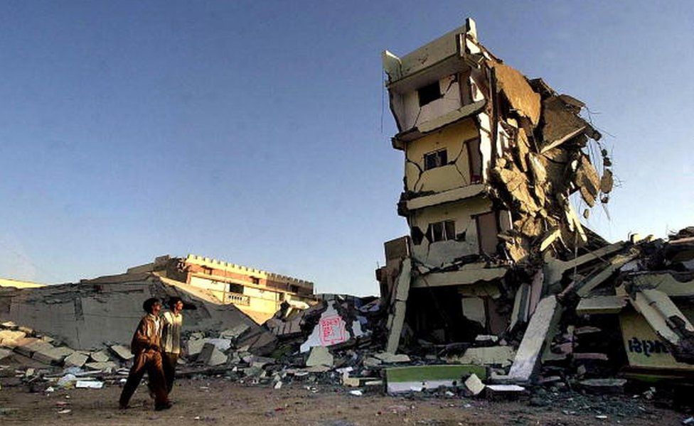 A couple of passersby look at a destroyed building 29 January 2001 where they used live in the town of Bhuj, in Gujarat state, which along with the entire northwestern India was hit by a massive earthquake 26 January.