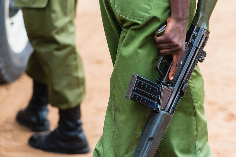 Anonymous uniformed Kenyan police officers hold guns