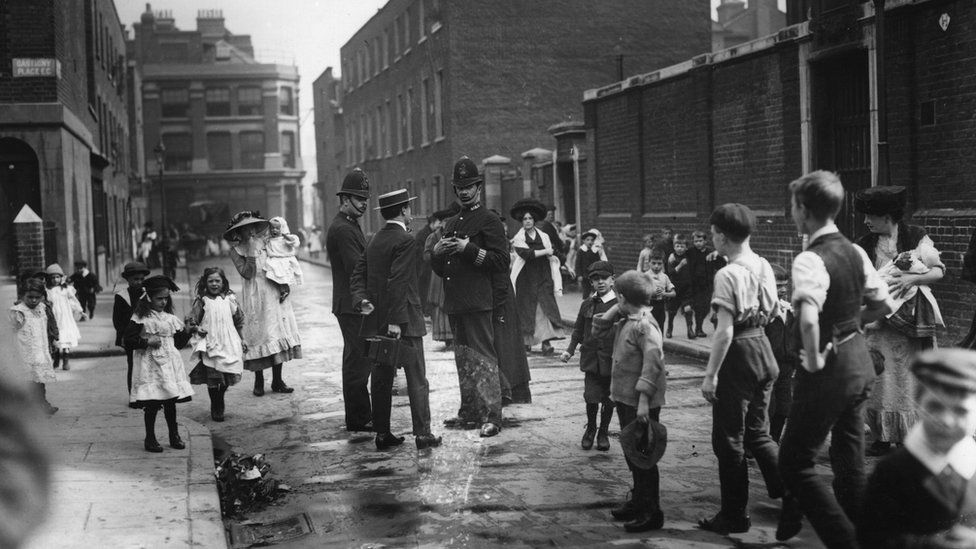 12th September 1911: The ringleaders of the Shoreditch schoolboys' strike waiting outside Bath Street School for students to come out. Two policemen and a photographer are also present