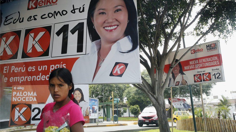 A woman sells candies in the street next to a sign of Peru"s presidential candidate Keiko Fujimori, in Surco, ahead of Sunday"s presidential election, in Lima, April 9, 2016