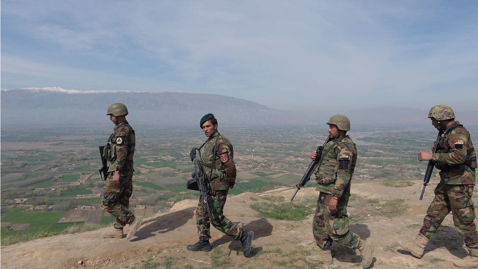 Afghan National Army (ANA) soldiers walk through Dand-e-Ghori district in Baghlan province