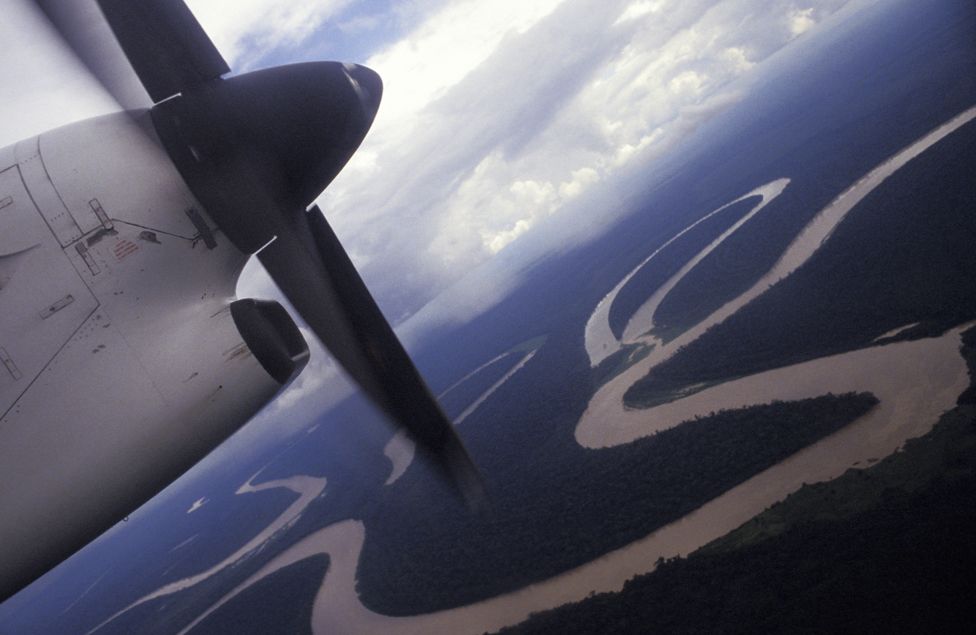 A small plane flying over the Amazon