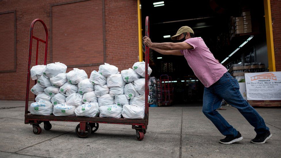 Феликс Пинзон, безработный строитель, толкает тележку с пожертвованиями на доставку еды 19 мая 2020 года в районе Бронкс в Нью-Йорке.