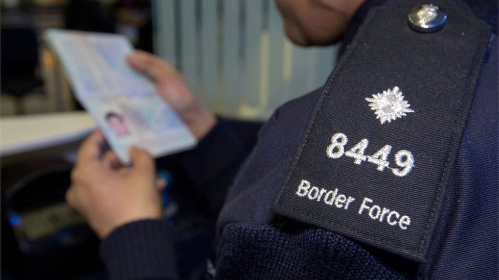 Border force official checking passport