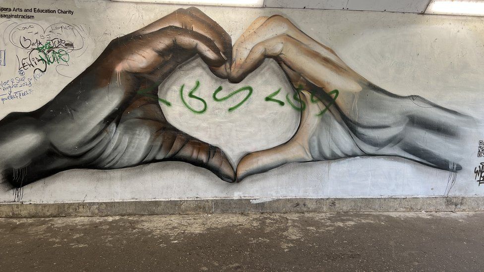 A mural featuring two hands in a heart shape