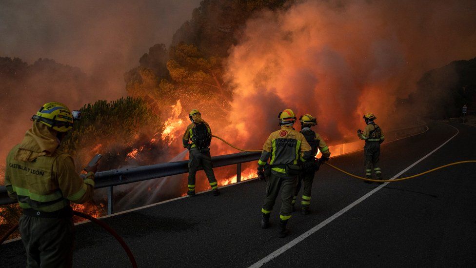 Firefighters from the Brigadas de Refuerzo en Incendios Forestales (BRIF) tackle a forest fire approaching to houses at El Hoyo de Pinares on July 18, 2022 in Avila, Spain.