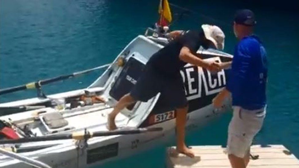 Andrew Baker being helped off the boat