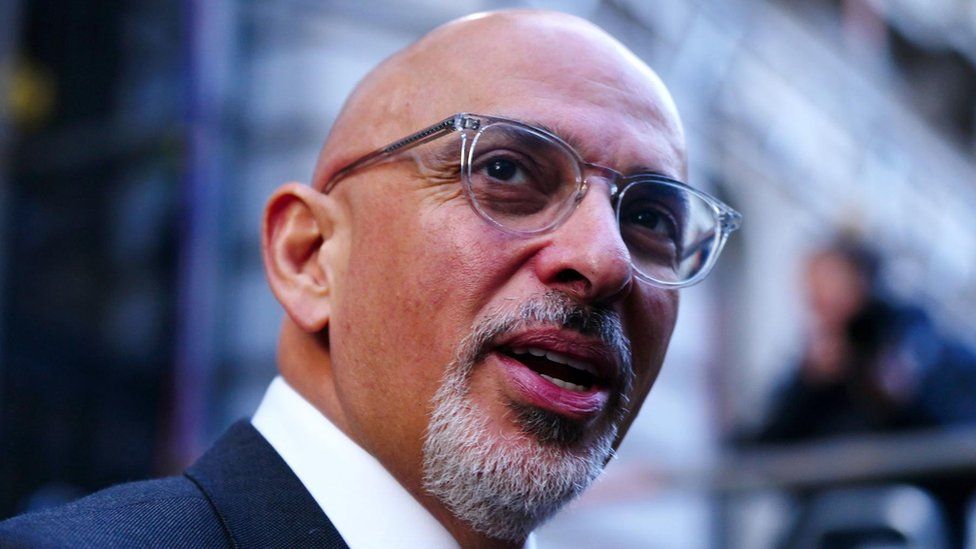 Nadhim Zahawi in close-up of his face, turning to camera and opening his mouth as if to speak in passing.