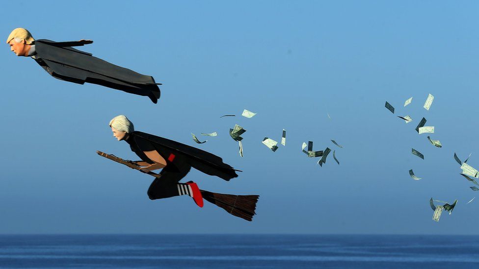 Model plane builder Otto Dieffenbach III makes his remote control plane resembling U.S. Presidential candidate Donald Trump release fake money as it flies over the beach next to a similar plane resembling Hillary Clinton in Carlsbad, California