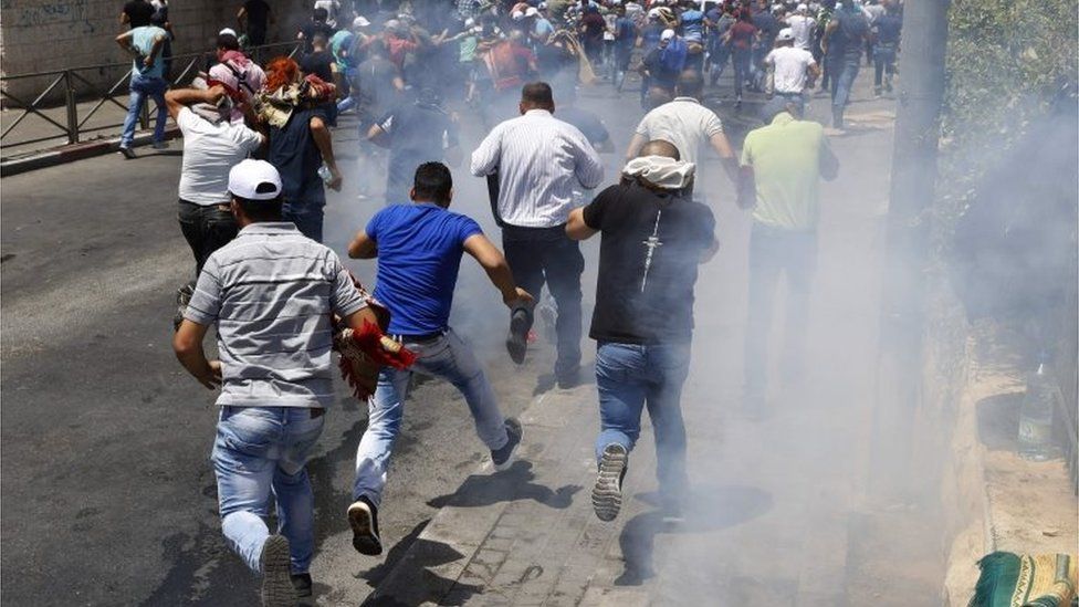 Palestinians run after stun grenades are fired outside Jerusalem's Old City (28/07/17)