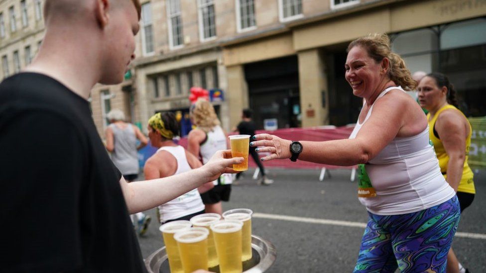 A runner gets a small beer during the 2021 course