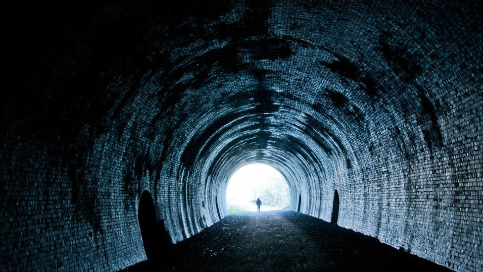A walker in one of four tunnels on the Monsal Trail