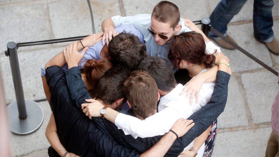 A group of mourners comfort each other on the streets of Las Rozas