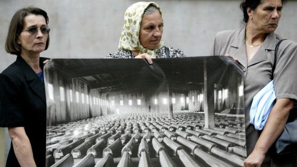 Survivors and relatives of victims of the Srebrenica massacre hold a picture of coffins at a protest in 2004