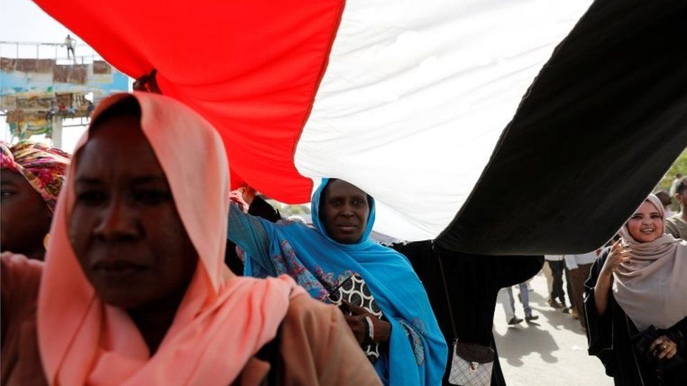 Sudanese protesters march under an national flag outside the defense ministry compound in Khartoum, Sudan, on 29 April 2019.
