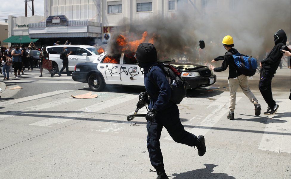 An LAPD vehicle burns after being set alight by protestors during demonstrations following the death of George Floyd, in Los Angeles, California, 30 May 2020