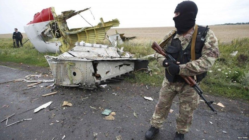 Pro-Russian rebel stands with debris from MH17 - July 2014 picture