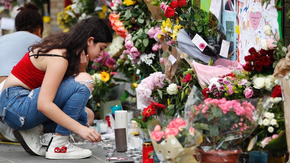 A girl lights a candle outside Notting Hill Methodist Church in west London