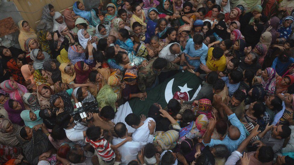 People surround the dead body of a Pakistani soldier allegedly killed by Indian firing, during a funeral in Faisalabad, Pakistan, Thursday, Sept. 29, 2016