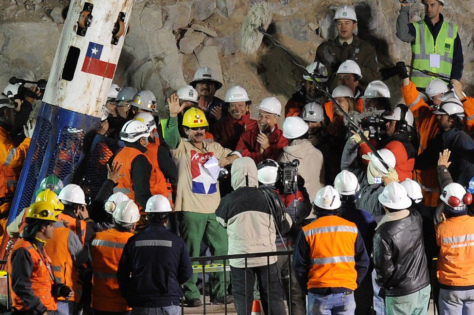 Chilean miner Juan Illanes celebrates after coming out of the Phoenix capsule, which brought him to the surface on 13 October 2010