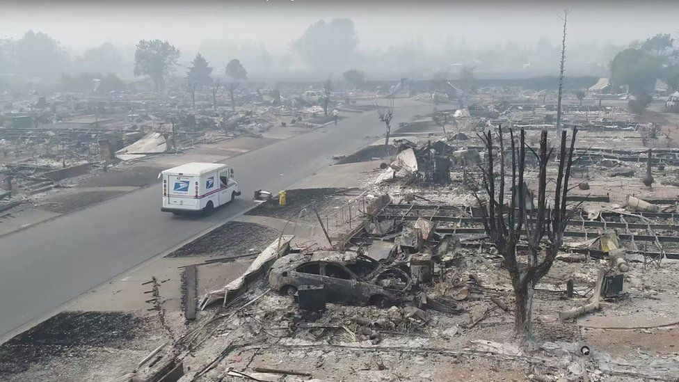 A postman delivers mail in a fire-devastated suburb of Santa Rosa, California