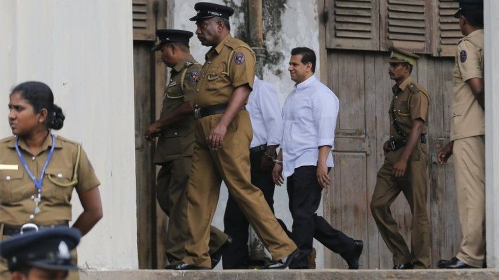 Шри-ланкийская полиция и тюремные офицеры сопровождают бывшего депутата Думинду Силву после того, как он был приговорен к смертной казни, в здании суда в Коломбо, Шри-Ланка, в четверг, 8 сентября 2016 г.