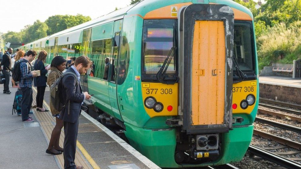 Commuters queue to get on a Southern train