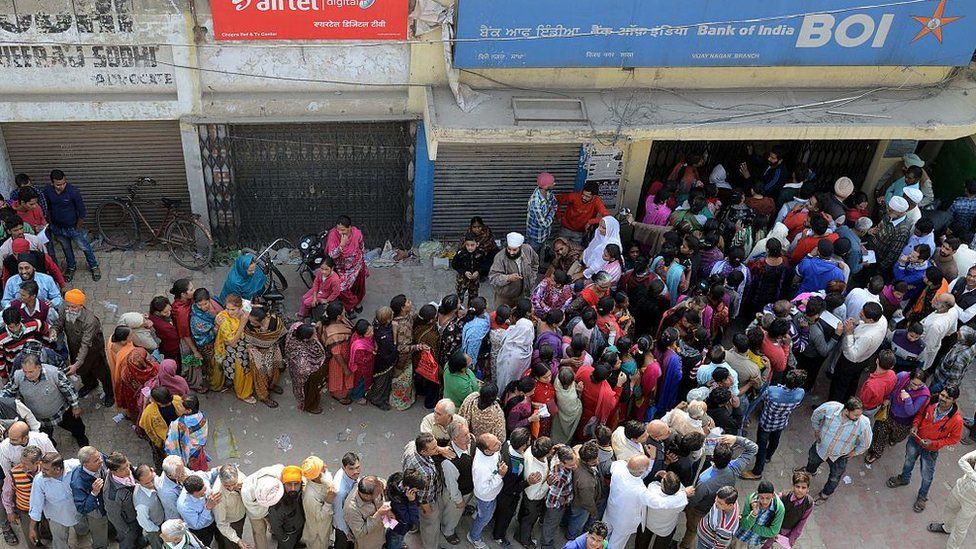 Indian people queue outside a bank as they wait to deposit and exchange 500 and 1000 Rupee notes in Amritsar